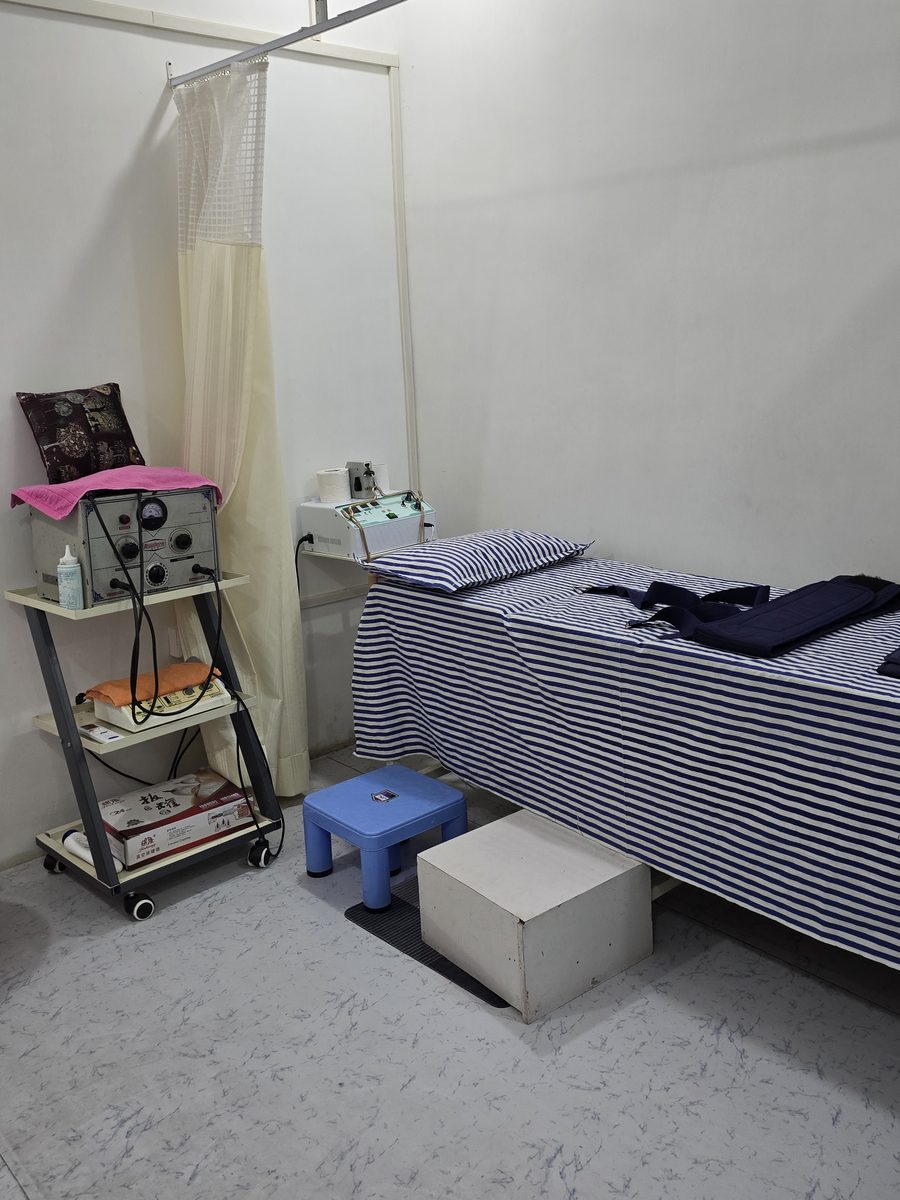 Curtained treatment bed with electrotherapy unit and trolley at MuvAgain Physiotherapy Patna